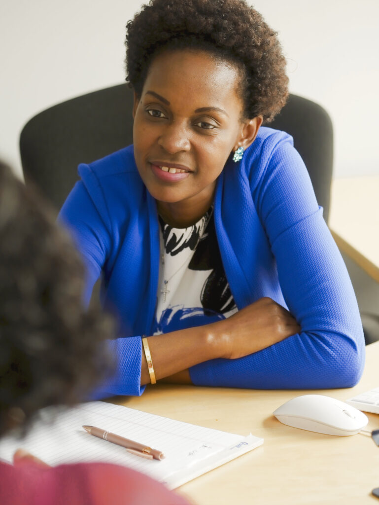 Consultant in a client meeting, taking notes across the table