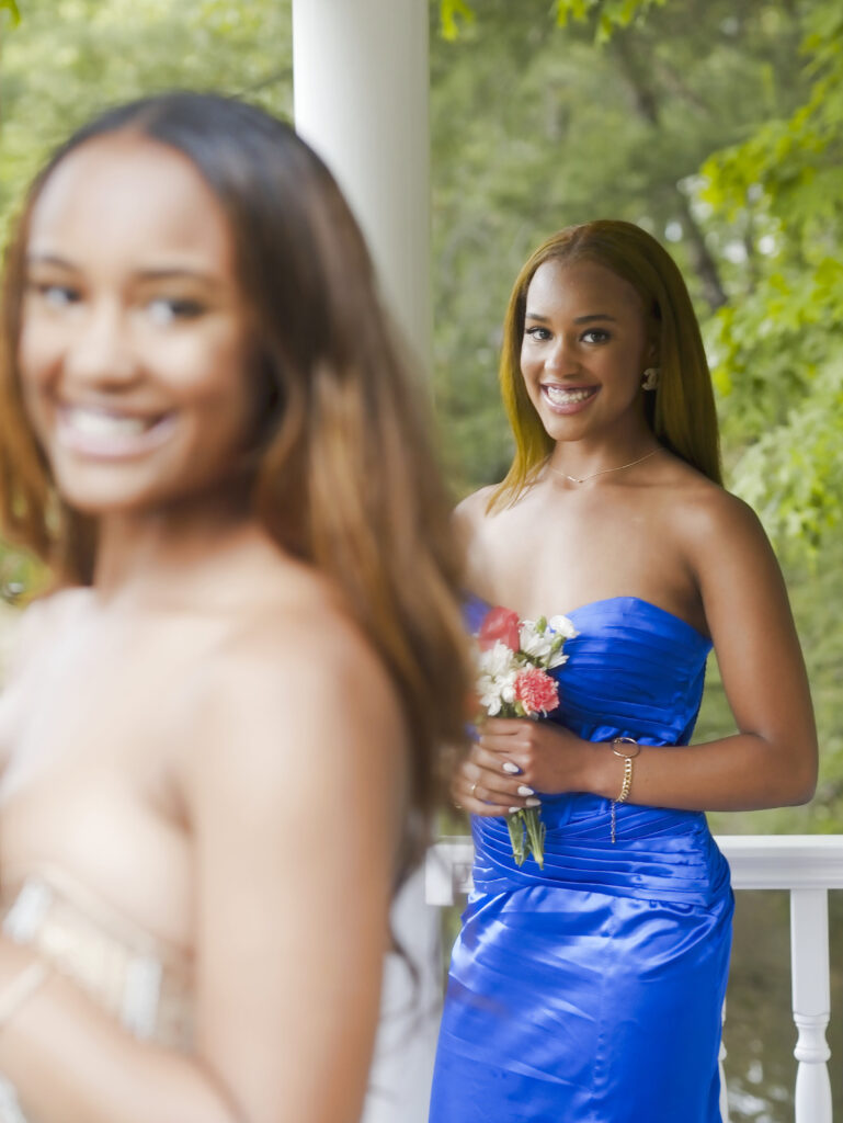 Two guests in formal gowns on a porch before the ceremony