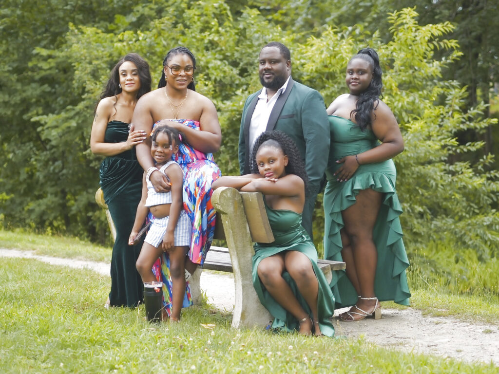 Extended family portrait outdoors in matching green